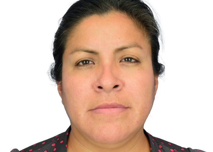 Close-up portrait of a woman facing the camera with a neutral expression against a white background.