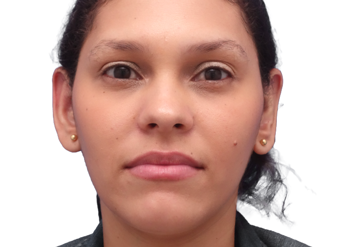 Close-up front-facing portrait of a woman with dark hair tied back against a white background.