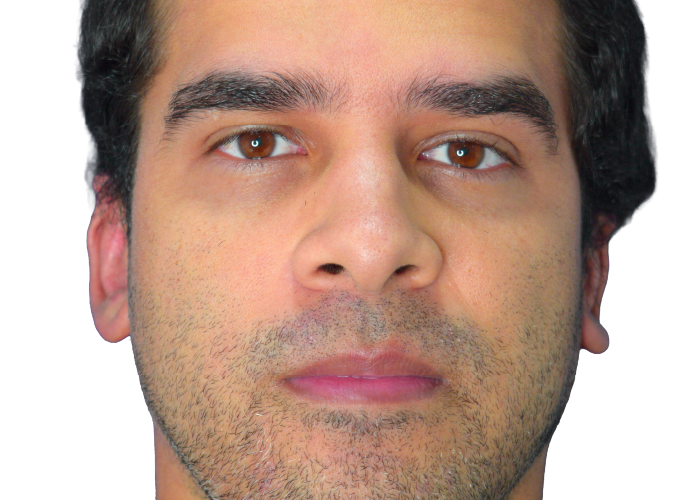 Close-up portrait of a man facing the camera with short dark hair and light stubble, neutral expression.
