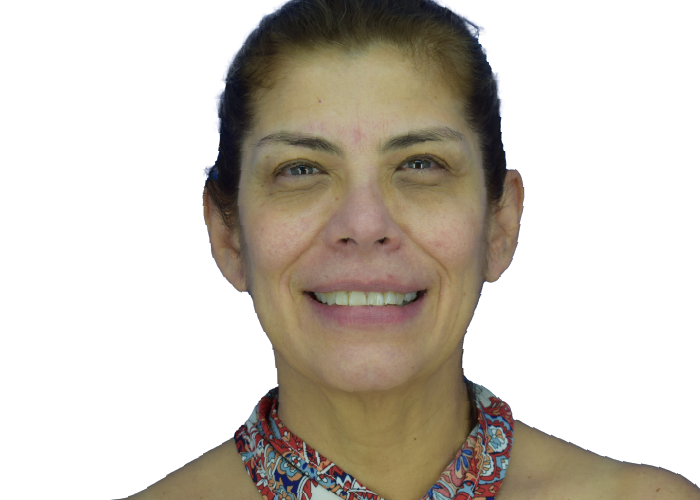 Portrait of a smiling woman with dark hair tied back, wearing a colorful floral scarf against a white background.