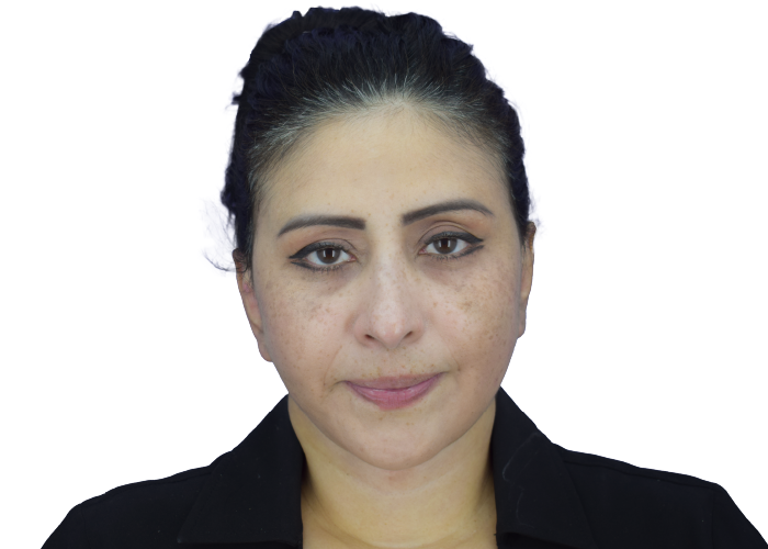 Close-up portrait of a woman with dark hair tied back, wearing a black blazer and a neutral expression.